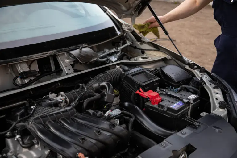 Technician working under the bonnet to remove AdBlue contamination on a commercial vehicle