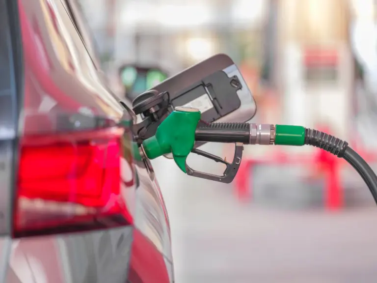 Fuel pump nozzle at a car filler cap - the moment of a diesel in petrol misfuelling mistake