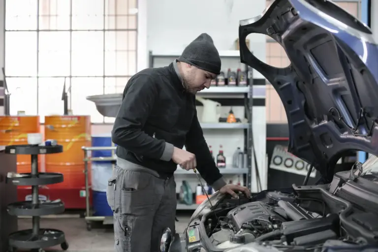 Technician inspecting a diesel car engine after a petrol in diesel misfuelling